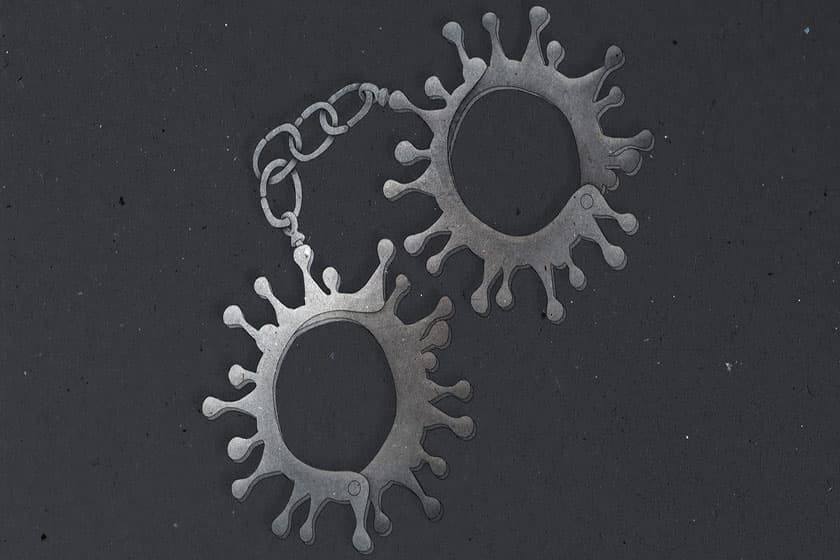 Two model coronavirus particles linked by a chain, photographed against a dark background.