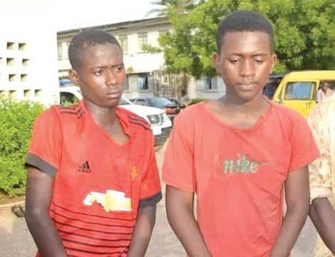 Two young boys in red T-shirts standing on a street in Kano — an illustrative photograph, not of the minor in the case.