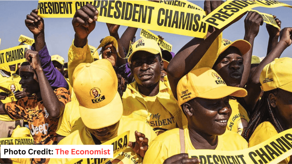 Supporters at a Zimbabwean opposition rally in yellow CCC shirts and caps, holding “President Chamisa” banners aloft. Photo credit: The Economist.